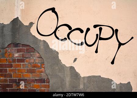 Handgeschriebene Graffiti besetzen an die Wand gesprüht, anarchistische Ästhetik Stockfoto