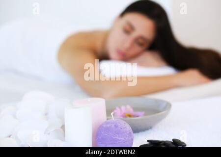 Weiße Handtücher mit Kerzen für eine entspannende Spa-Massage und Körperbehandlung. Spa mit Steinen und Salz auf. Stockfoto