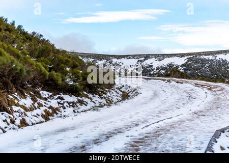 Gefrorener Pfad zwischen Bergen mit Fußabdrücken von Menschen und Tieren Im Schnee markiert Stockfoto