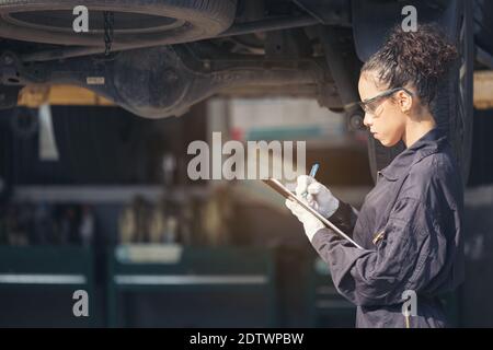 Mechaniker, der die Unterseite beim Autoservice untersucht, Auto-Reparatur-Service. Stockfoto