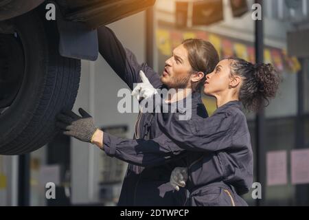 Mechaniker, der die Unterseite beim Autoservice untersucht, Auto-Reparatur-Service. Stockfoto