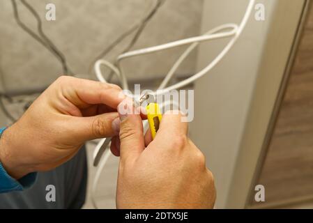 Elektriker anschließen der Kabel der TV-Antenne während der Renovierung des Hauses. Master Montage TV-Kabel Stockfoto