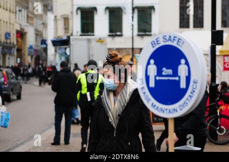 Cambridge UK, 22-12-2020,Erwachsene tragen Gesichtsmaske geht vorbei an Weihnachtsbaum Stockfoto