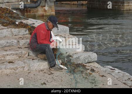 Qaqortoq, Grönland - 28. August 2017: Inuit eskimo Mann bereitet frischen Fisch auf einem Markt in Qaqortoq Grönland. Stockfoto