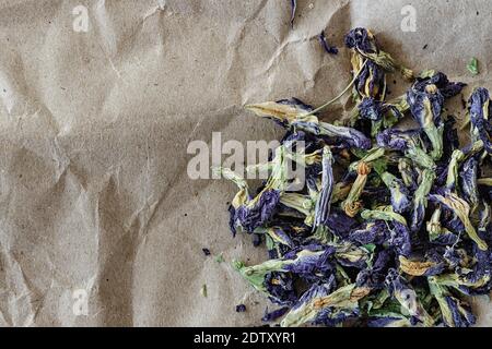 Selektiver Fokus topview von Anchan Blume Kräutertee Clitoria ternatea, auf einem Blatt Kraftpapier. Foto mit negativem Raum. Stockfoto