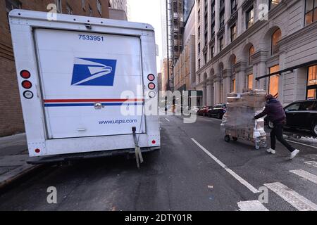 New York, USA. Dezember 2020. Ein Mann schiebt einen Handwagen mit Paketen in die 58th Street in New York, NY, 21. Dezember 2020. Mit einem Wiederaufleben von COVID-19-Infektionen erwarten Paketversanddienste wie FEDEX, UPS und die USPS, eine Rekordzahl von Paketen für 2020 zu liefern. (Foto von Anthony Behar/Sipa USA) Quelle: SIPA USA/Alamy Live News Stockfoto