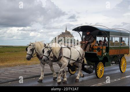 Pferdewagen mit Besuchern am Mont St. Michel in Bretagne, Frankreich Stockfoto