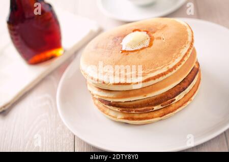 Leckere Pfannkuchen mit Ahornsirup auf einem Teller. Stockfoto