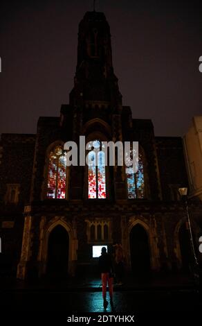 Brighton UK 22. Dezember 2020 - Weihnachtseinkäufer kommen an der Installation "Murmurations" vorbei, die an diesem Abend auf die Fenster der Fabrica Gallery in Brighton projiziert wird. Die Installation des Künstlerkollektivs Shared Space & Light wurde ausgewählt, um das Gebäude bis Ende Januar zu beleuchten und zeigt die berühmten Sternmurmeln, die jedes Jahr vor der Küste zu sehen sind : Credit Simon Dack / Alamy Live News Stockfoto