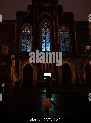 Brighton UK 22. Dezember 2020 - Weihnachtseinkäufer kommen an der Installation "Murmurations" vorbei, die an diesem Abend auf die Fenster der Fabrica Gallery in Brighton projiziert wird. Die Installation des Künstlerkollektivs Shared Space & Light wurde ausgewählt, um das Gebäude bis Ende Januar zu beleuchten und zeigt die berühmten Sternmurmeln, die jedes Jahr vor der Küste zu sehen sind : Credit Simon Dack / Alamy Live News Stockfoto