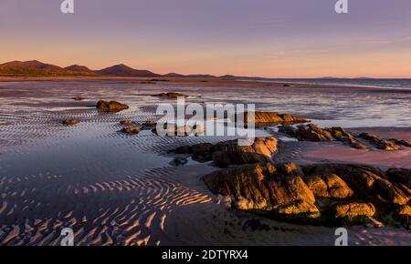 Die wunderschöne Küste von South Uist bei Sonnenuntergang, eine der westlichen Inseln von Schottland, Vereinigtes Königreich. Stockfoto