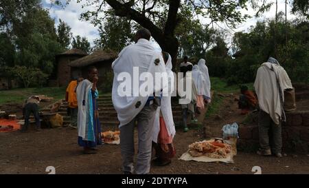 Lalibela-Äthiopien: 12. April 2019: Straßenmarkt in Lalibela mit Menschen in traditionellen weißen Untiefen Stockfoto