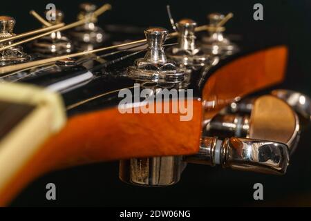 Nahaufnahme eines Gitarrenkopfes mit Mechanik und Saiten Stockfoto