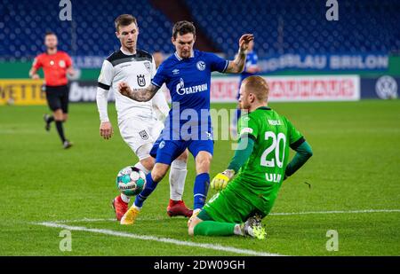 Gelsenkirchen, Deutschland. Dezember 2020. Fußball: DFB Cup, SSV Ulm 1846 - FC Schalke 04, 2. Runde in der Veltins Arena. Ulmer Torwart Maximilian Reulen (r-l) kommt vor Schalkes Benito Raman und Ulmer Thomas Geyer an den Ball. Quelle: Guido Kirchner/dpa - WICHTIGER HINWEIS: Gemäß den Bestimmungen der DFL Deutsche Fußball Liga und/oder des DFB Deutscher Fußball-Bund ist es untersagt, im Stadion und/oder des Spiels aufgenommene Fotos in Form von Sequenzbildern und/oder videoähnlichen Fotoserien zu verwenden oder zu verwenden./dpa/Alamy Live News Stockfoto