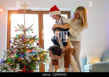 Junge Familie mit Spaß Dekoration Weihnachtsbaum Stockfoto