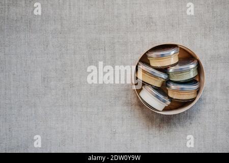 Nüsse und Samen Butter in Gläsern auf Naturstoff-Hintergrund mit Copyspace. Hausgemachte rohe Bio-Erdnuss, Mandel, Kokosnuss, Hanfsamen, Kürbis Stockfoto