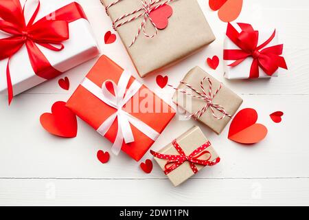 Valentinstag Geschenk-Boxen, flach Lay, Draufsicht. Papierherzen und romantische Geschenke auf weißem Holztisch Hintergrund. Stockfoto