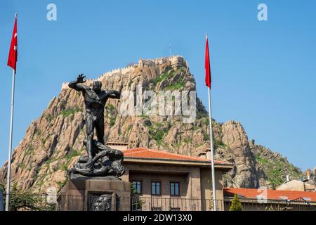 AFYONKARAHISAR, TÜRKEI, APRİL 26,2019:: Afyonkarahisar Castle und Afyon Atatürk Buyuk Utku Monument. Die Burg auf einem vulkanischen Gesteinsmasse gelegen. Stockfoto