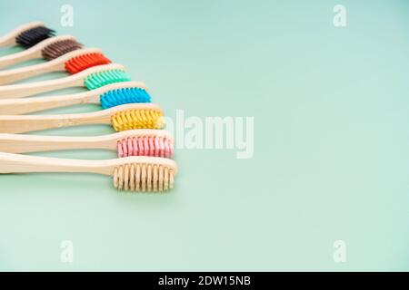 Ein Set umweltfreundlicher antibakterieller Zahnbürsten aus Bambusholz auf hellgrünem Hintergrund. Trends im Bereich Umweltschutz. Stockfoto
