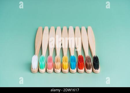 Ein Set umweltfreundlicher antibakterieller Zahnbürsten aus Bambusholz auf hellgrünem Hintergrund. Trends im Bereich Umweltschutz. Stockfoto