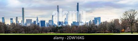 Einköpfige Person im Central Park, die am gut beleuchteten Bogen vorbeigeht Trister Tag mit Herbstlaub im Vordergrund Stockfoto