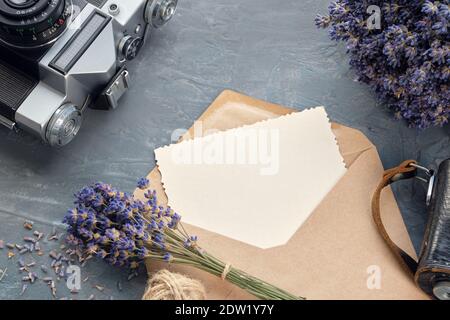 Grußkarte, Retro-Kamera und Lavendel Blumensträuße auf grauem Hintergrund. Flach liegend. Stockfoto