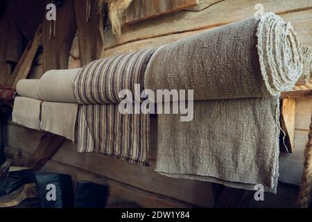 Rollen aus natürlichem Leinenstoff auf einem Holzregal in einem Retro-Shop. Stockfoto