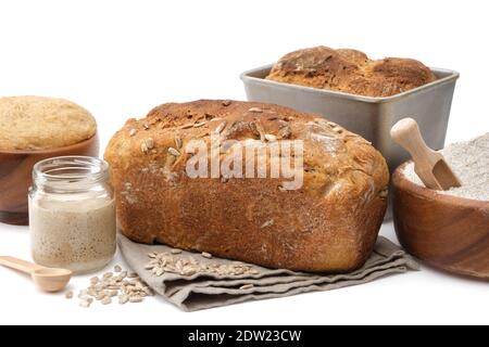 Hausgemachtes Sauerteig Brot, natürlicher Sauerteig für Brot in einem Glas, Holzschüssel mit Teig und Schüssel Mehl auf weiß. Stockfoto