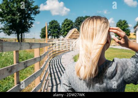 Cottagecore, Landästhetik, Landwirtschaft, Farmcore, Countrycore, langsames Leben. Junges Mädchen in Bauernkleid und mit Blumen genießen die Natur auf Stockfoto