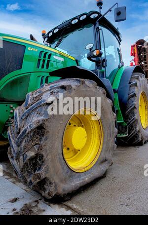 Ein 6215R John Deere 4-WD-Traktor mit einem Reifenschaden an den Vorderrädern. Stockfoto