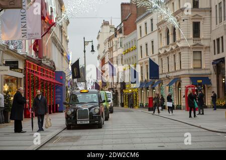 London, Großbritannien. Dezember 2020. Die Leute laufen entlang der New Bond Street.unter Tier 4 Einschränkungen müssen nicht-wesentliche Geschäfte, Friseure und Freizeit- und Unterhaltungsmöglichkeiten schließen. Quelle: Pietro Recchia/SOPA Images/ZUMA Wire/Alamy Live News Stockfoto