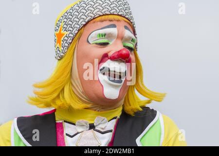 Isoliertes Porträt eines lateinamerikanischen fröhlichen lächelnden Comic-Clowns Durchführung mit glücklichen Gesicht trägt bunte Kostüm, rote Nase, gelbe Haare Und Farbe Stockfoto