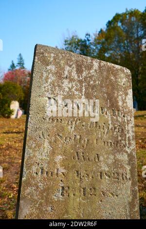 Ein schlichtes, altes Steingrab, bedeckt mit Moos und Flechten. Im Bay View Cemeteryl in Surry, Maine. Stockfoto