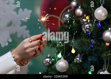 Mädchen hält einen brennenden Funkler in ihren Händen. Stockfoto