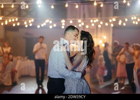 Braut und Bräutigam küssen sich im Restaurant bei der Hochzeit. Glückliches Jungvermählte auf der Hochzeitsfeier Stockfoto