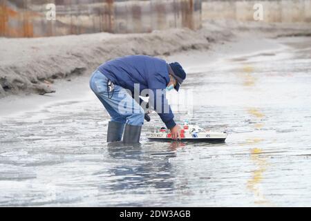 Mann mit Modellboot schwimmt es im See Stockfoto