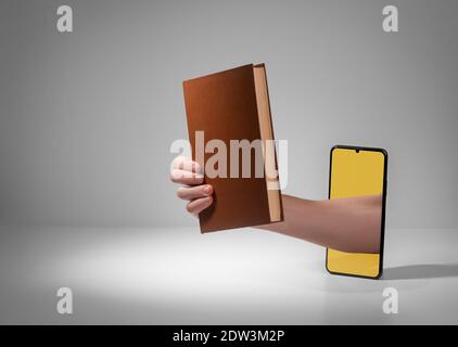 Hand, die ein Buch von einem Telefonbildschirm aus gibt Stockfoto