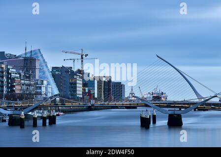 Spektakulärer Blick auf die Stadt am Morgen über den Liffey mit modernem Gebäude und der Samuel Beckett Brücke, die von Santiago Calatrava, Dublin, Irland, entworfen wurde Stockfoto