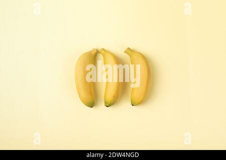 Drei frische Bananen isoliert auf gelbem Hintergrund Stockfoto