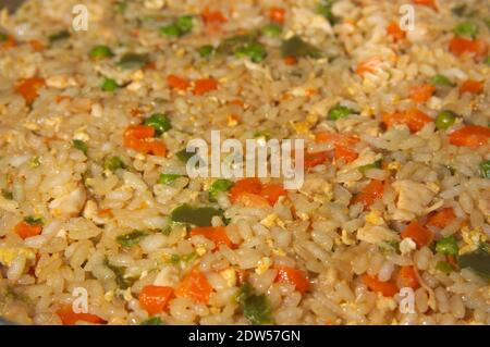 Bild von Teller mit Reis im Stil von chinesischem Reis gekocht drei Köstlichkeiten mit grünem Pfeffer, Karotte, Erbsen, Ei und Fleisch Stockfoto