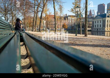 Den Haag, Den 9. November 2020. Den Haag, Niederlande. Zwei Frauen plaudern während der Sperre auf einer Parkbank in einer verlassenen Stadt. Covid-19 pandem Stockfoto