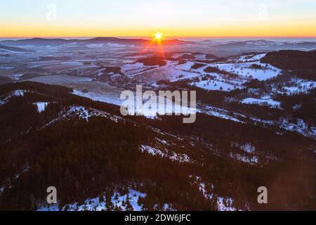 Panoramablick auf die Adler- und Jesenik-Berge vom Kralicky Sneznik-Gipfel im Winter bei Sonnenuntergang. Schnee liegt auf Hügeln mit vielen Bäumen. Stockfoto