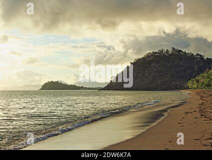 Am frühen Morgen spielen Wolken und Sonnenlicht am Trinity Beach, der südliche Blick zurück in Richtung Cairns QLD Australia Stockfoto