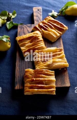 In Scheiben geschnittene Dartois mit Birnen - french Blätterteig Torte mit Früchte und Frangipane auf dunkelblauem Hintergrund Stockfoto