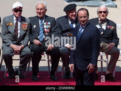 Der französische Präsident Francois Hollande erwartet die Ankunft ausländischer Würdenträger, während Veteranen des Zweiten Weltkriegs im Hintergrund bei einer internationalen Zeremonie zum 70. Jahrestag der Landung der Alliierten am D-Day am Sword Beach in Ouistreham, in der Normandie, Frankreich, am 06. Juni 2014 sitzen. Mehr als 75,000 britisch-kanadische und andere Commonwealth-Truppen landeten am 06. Juni 1944 an den Stränden der Normandie neben den Vereinigten Staaten und den Freien Franzosen, bei einer alliierten Invasion von mehr als 130,000. Weitere 7,900 britische Truppen wurden von Air.The Invasion gegründet eine entscheidende zweite Front in der Befreiung von E Stockfoto