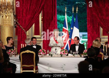 Die britische Königin Elizabeth II. (C) hält eine Rede, während der französische Präsident Francois Hollande (R) und der französische Premierminister Manuel Valls bei einem Staatsessen im Pariser Elysee-Präsidentenpalast im Anschluss an die internationalen D-Day-Gedenkfeiern in der Normandie zuhören. Anlässlich des 70. Jahrestages der Landung der Alliierten im Zweiten Weltkrieg in der Normandie. Foto von Hamilton/Pool/ABACAPRESS.COM Stockfoto