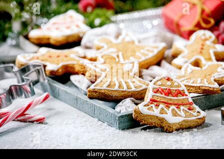 Hausgemachte traditionelle Weihnachten Lebkuchenkekse mit Verzierung verziert. Lebkuchenmann, Engel, Glocke mit Weihnachtsdekorationen auf weißem Bokeh Hintergrund. Stockfoto