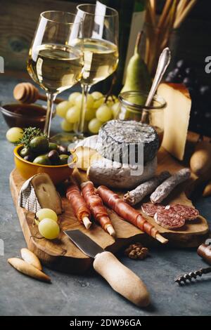 Weißwein mit Wurstwaren Sortiment auf den Stein. Wein und Snacks einstellen Stockfoto
