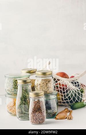 Obst und Gemüse in wiederverwendbaren Baumwolle Taschen und Gläsern mit Pasta, Linsen, Bohnen, Reis, trockene Kräuter. Null Abfall, Recycling, nachhaltiger Lebensstil Stockfoto