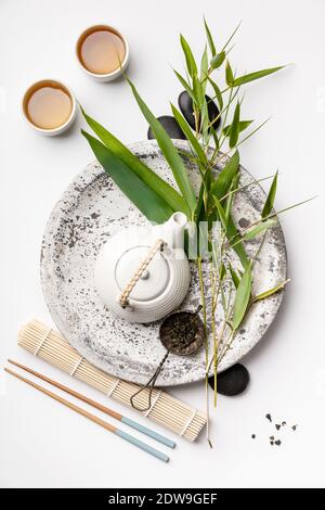 Bambus Niederlassungen und grünen Tee auf weißem Hintergrund, Asian Food Konzept, flach Stockfoto